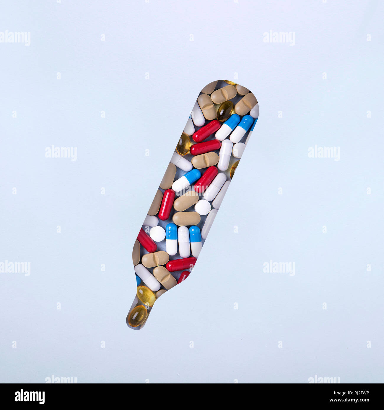 Thermometer with pills and pills Minimalism. The concept of first aid in case of heat, temperature. Home treatment Stock Photo