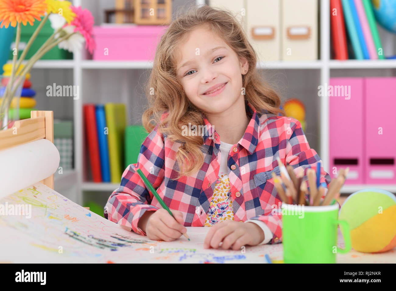 Portrait of cute curly girl drawing colored pencils Stock Photo - Alamy