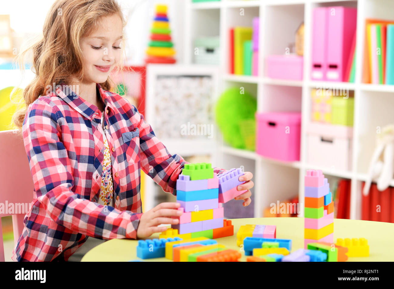 Portrait of girl playing with plastic blocks Stock Photo - Alamy