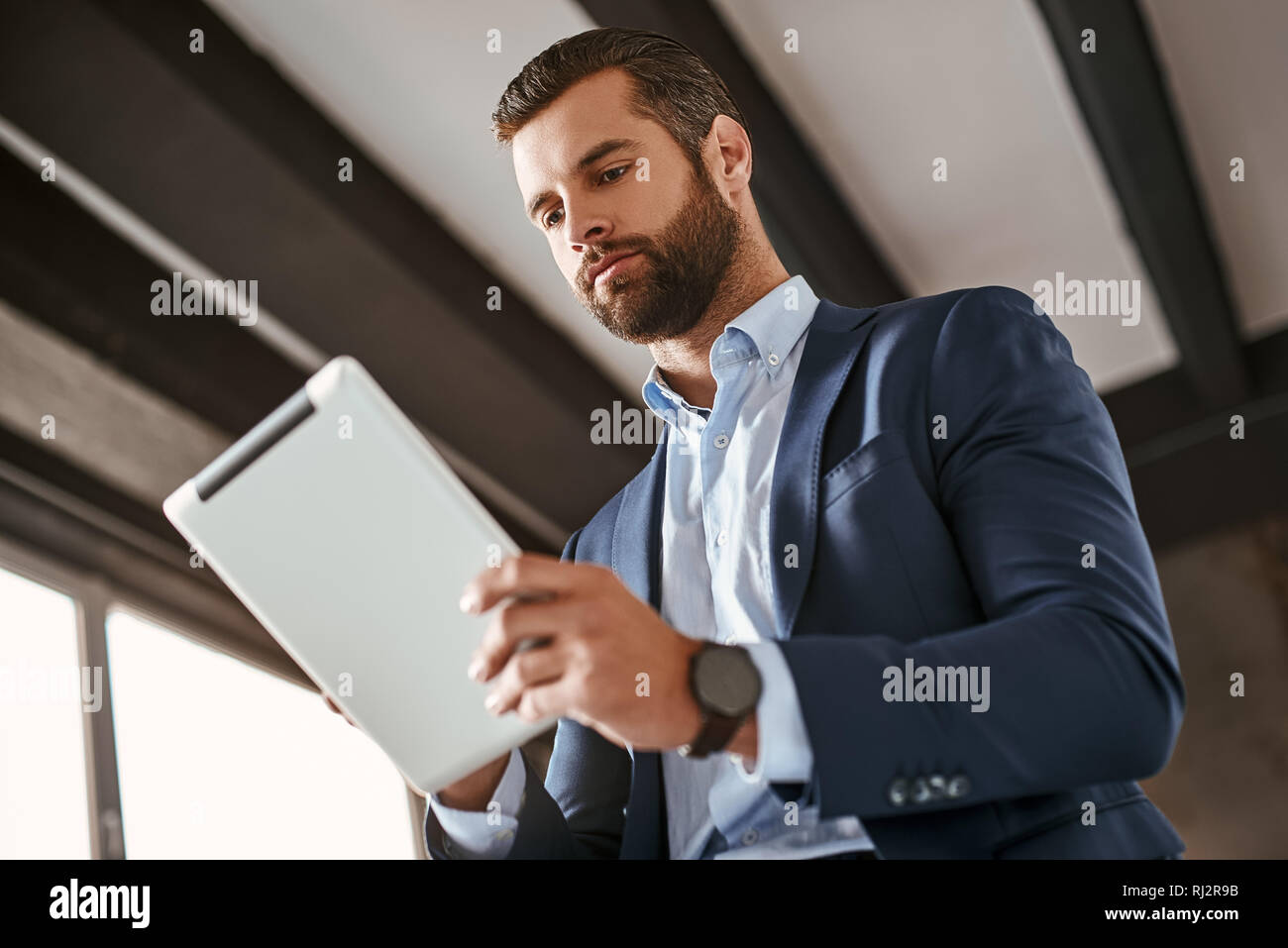 Time To Work Confident Bearded Young Businessman In Stylish Suit Is Using Digital Tablet At Office Business Style Fashion Look Stock Photo Alamy