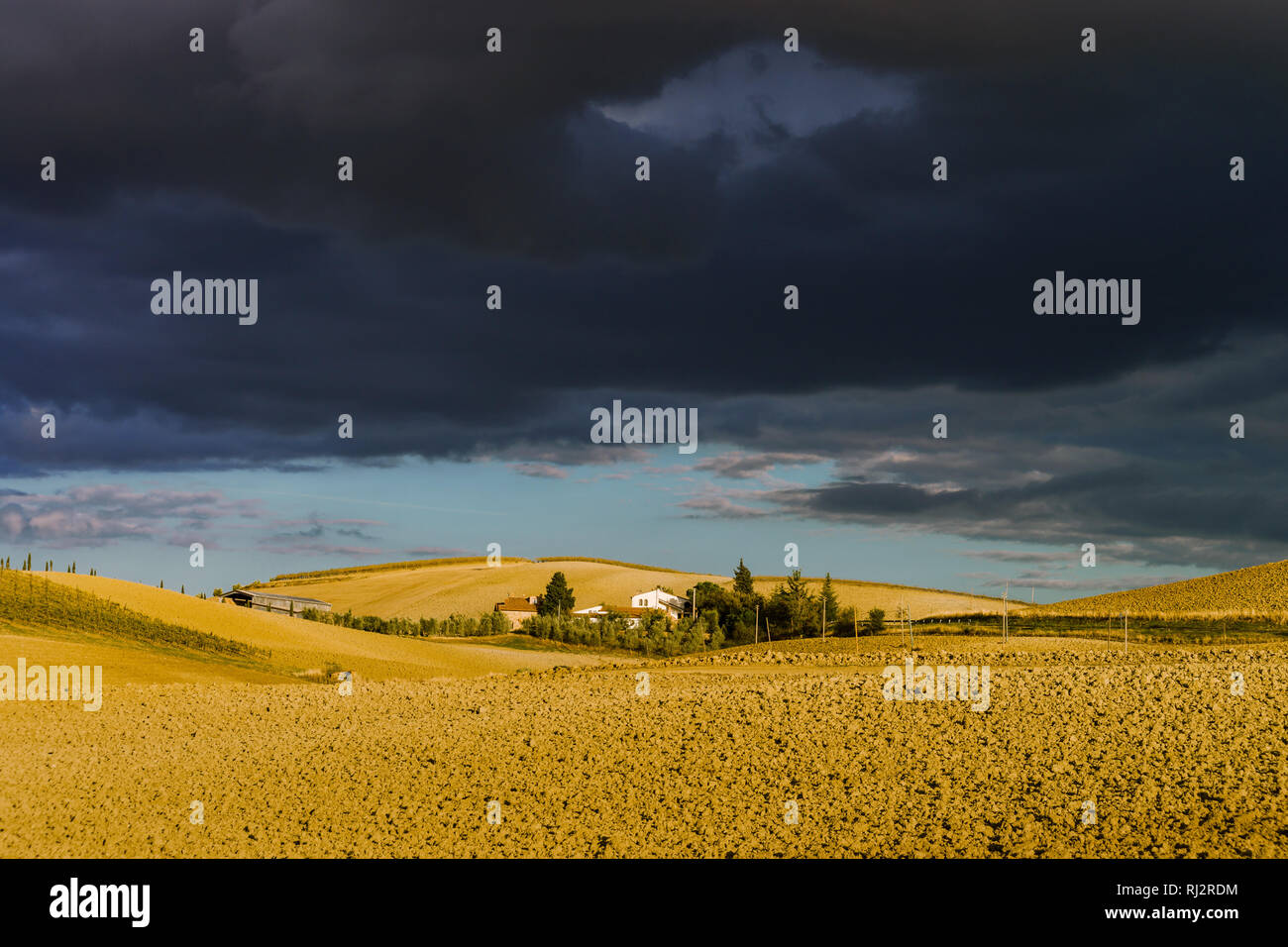 Villa in Italy, old farmhouse in the waves of tuscanian fields and hills, autumn, stormy weather Stock Photo