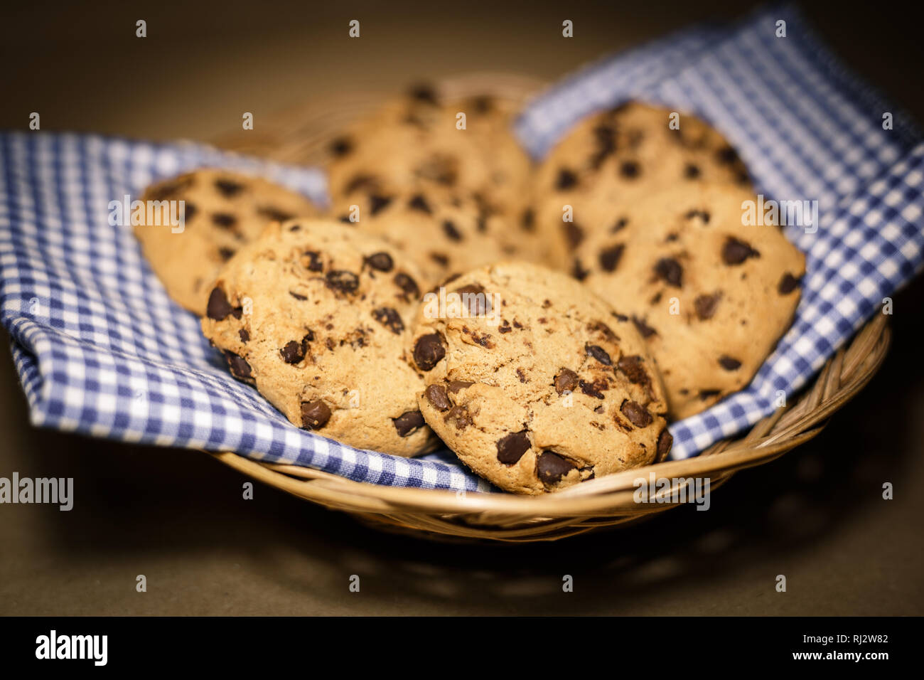 Chocolate chips cookies in a wooden basket . Food photography theme in vintage or retro color style. Stock Photo