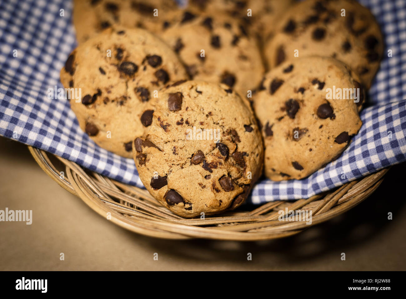 Chocolate chips cookies in a wooden basket . Food photography theme in vintage or retro color style. Stock Photo