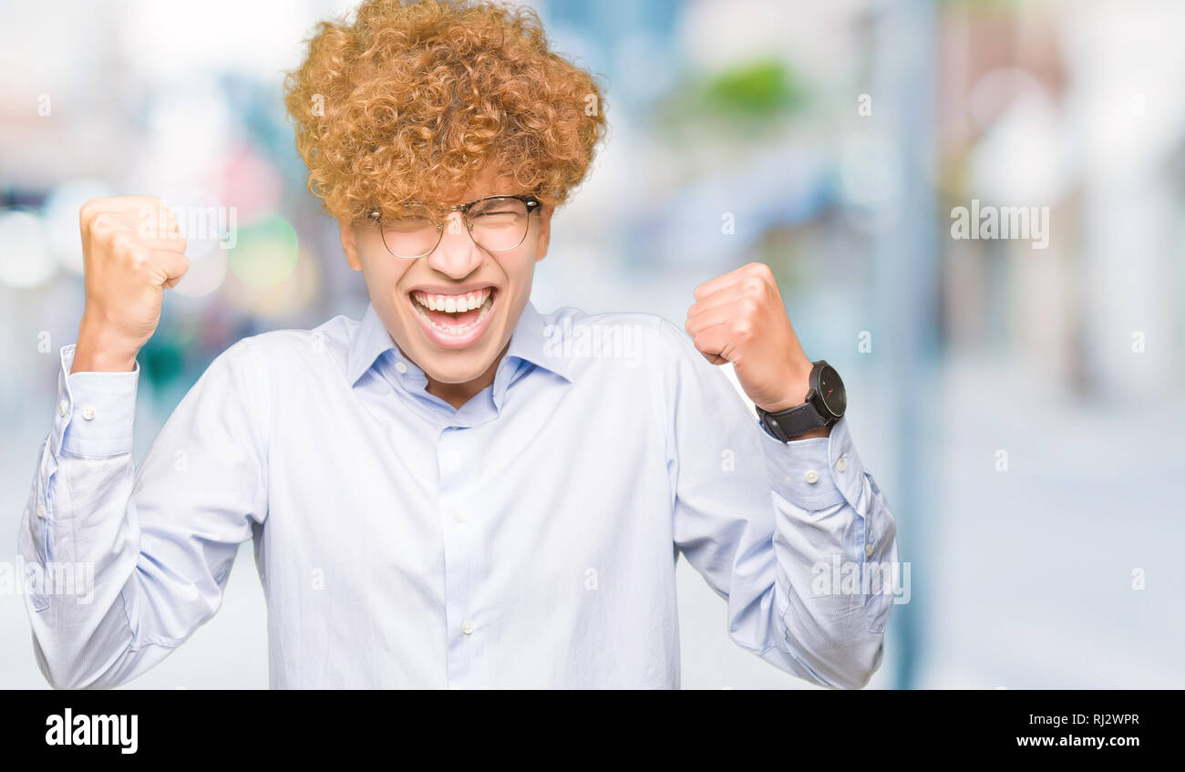 Young handsome business man with afro wearing glasses very happy and ...