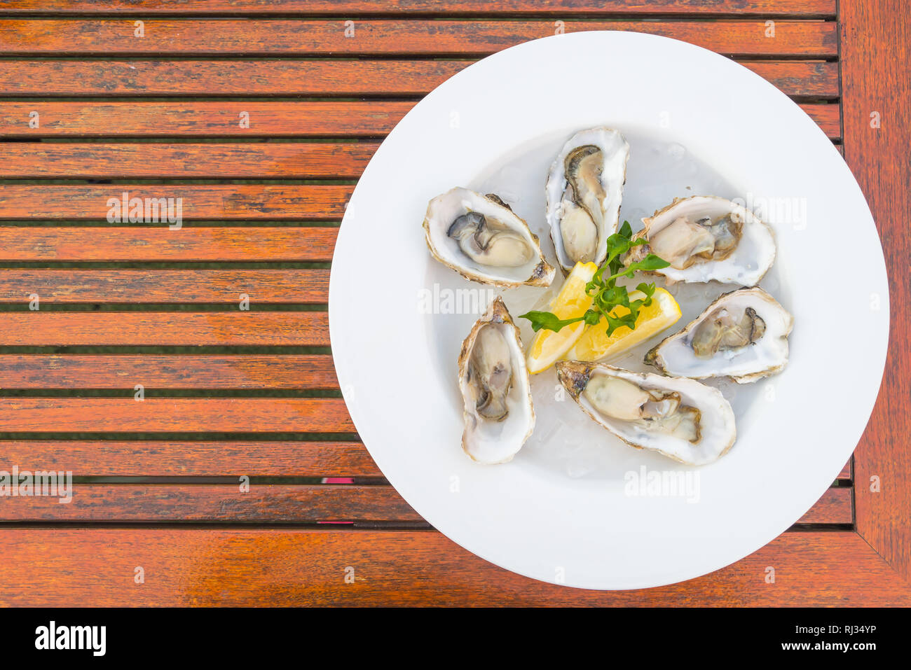 Selective focus point on fresh oysters shell with lemon - Top of view Stock Photo