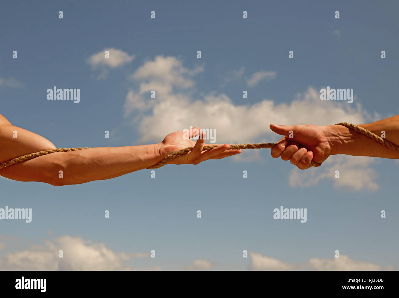 Under extreme tension. Athletic contest. Tug war is a sport. Male hands