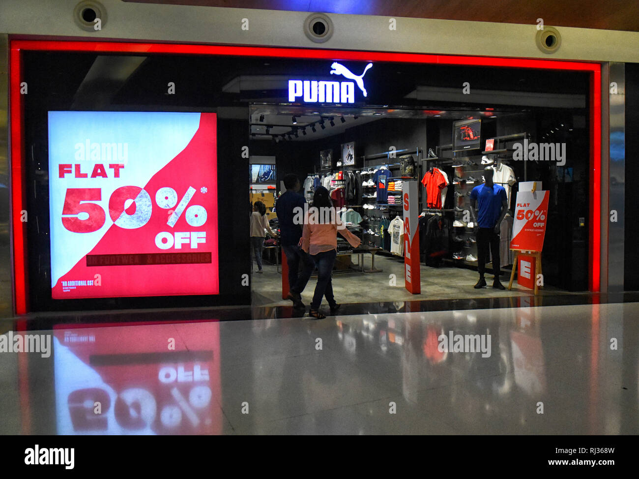 A couple seen walking into a Puma shop with a 50 % discount going on for  special Winter sales at the South City Mall Kolkata Stock Photo - Alamy