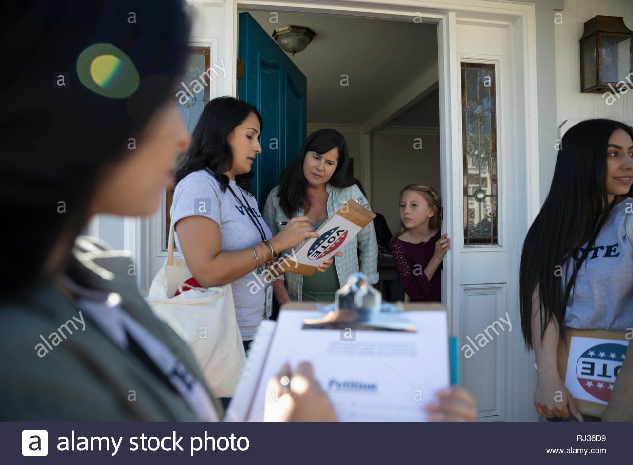 Latinx Women Volunteers Canvassing Voters Door To Door Stock