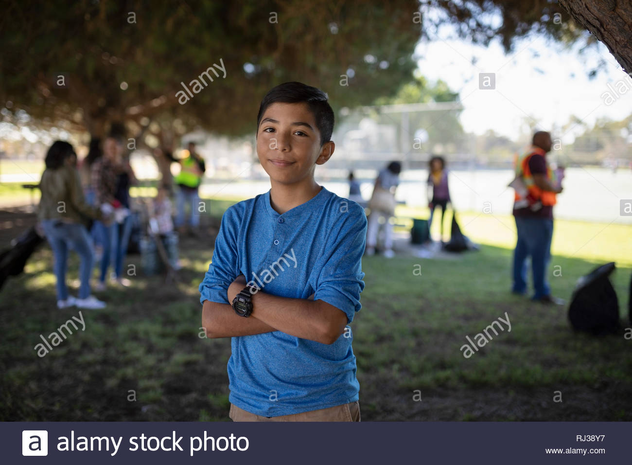 Portrait confident Latinx boy volunteering, cleaning park Stock Photo