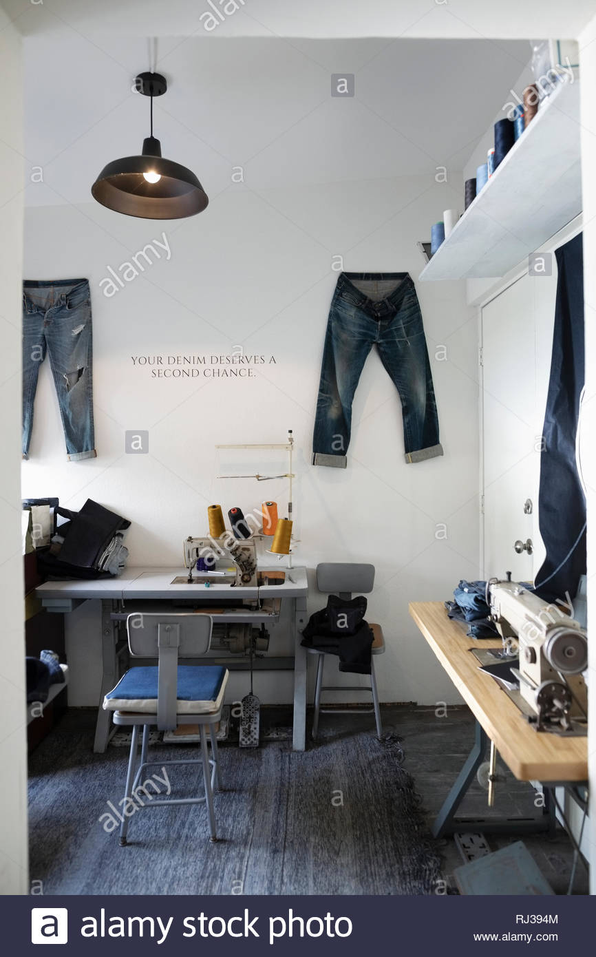 Sewing machines and jeans in denim repair shop Stock Photo Alamy