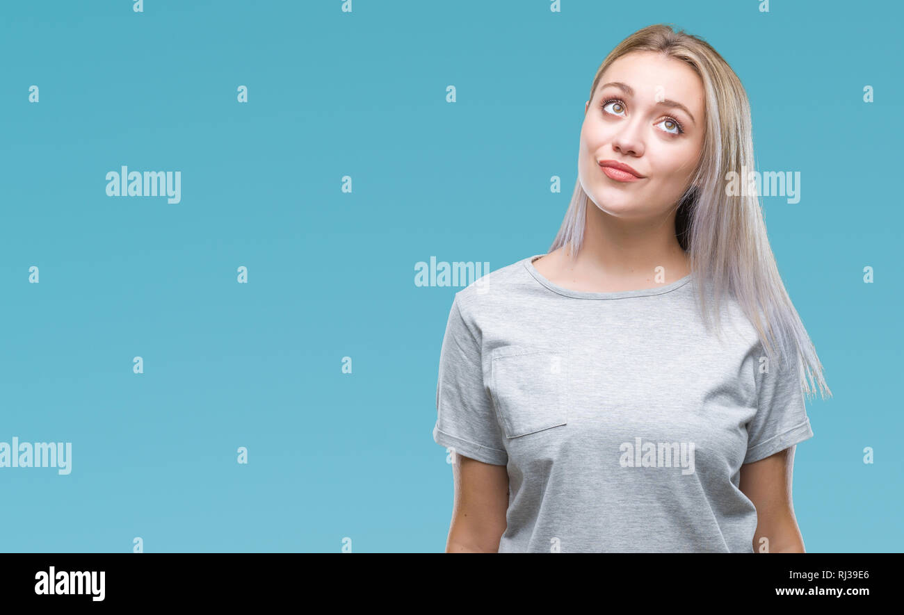 Young blonde woman over isolated background smiling looking side and ...