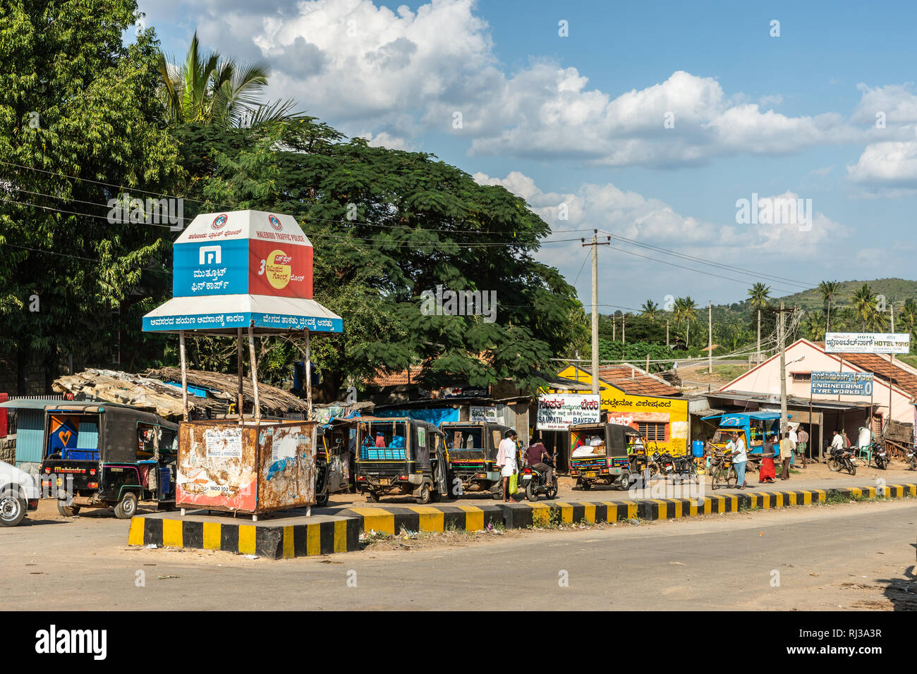 Halebidu, Karnataka, India - November 2, 2013: Street view of the town near Hoysalaswara temple, with small car traffic, bikes and people. Green belt  Stock Photo