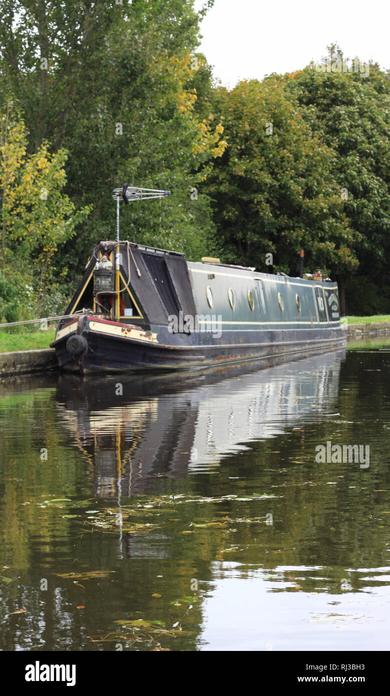 grey narrow boat moored on canal Stock Photo