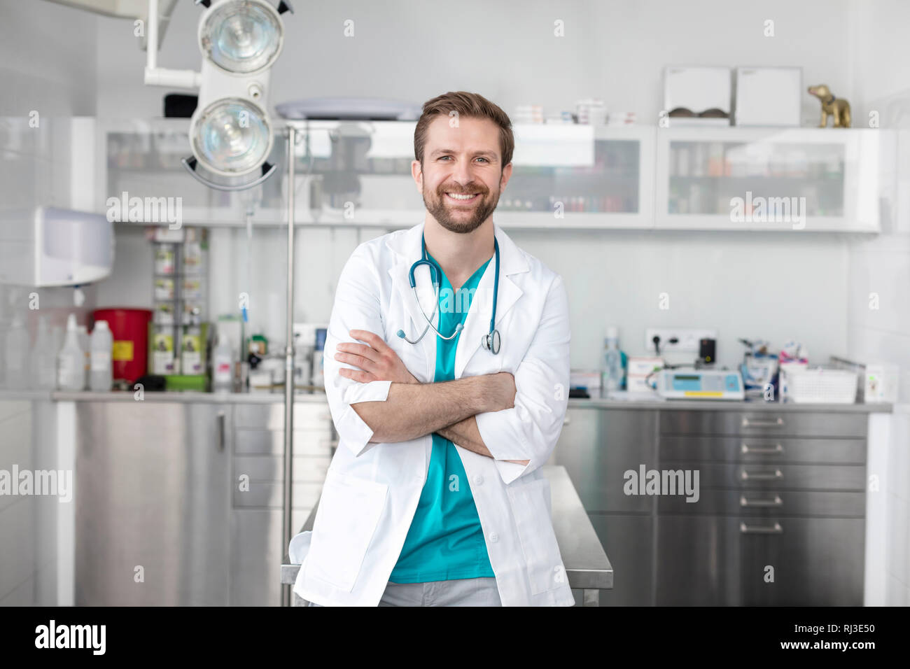 Portrait of smiling doctor standing with arms crossed at veterinary clinic Stock Photo