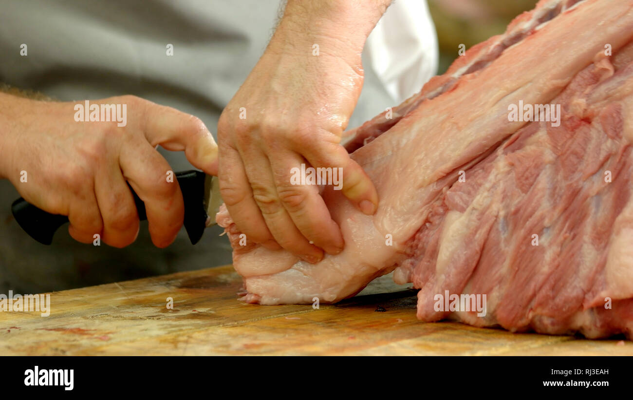 Butcher holding large knife and meat - Stock Image - F006/4436