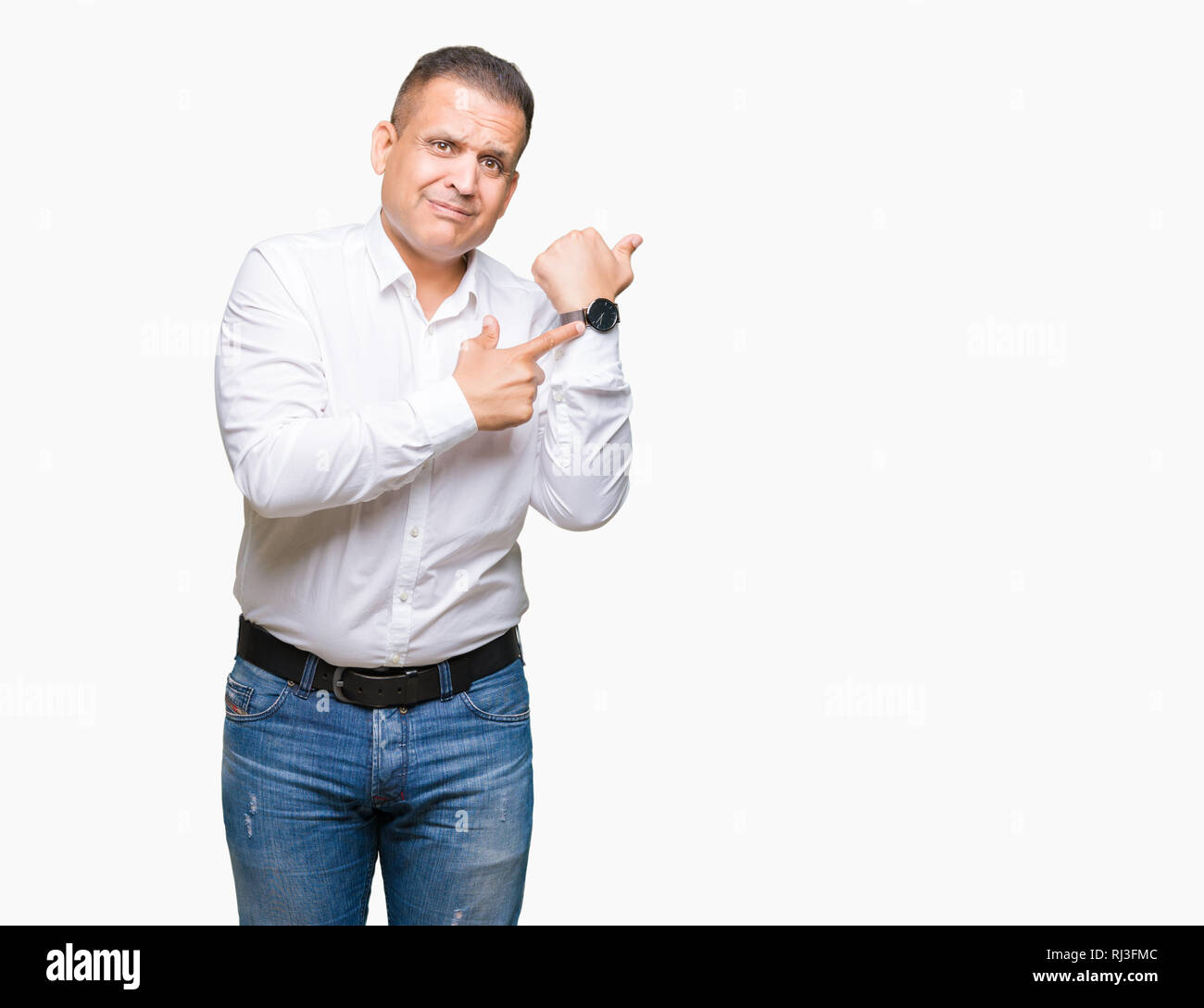 Middle age arab elegant man over isolated background In hurry pointing to watch time, impatience, upset and angry for deadline delay Stock Photo