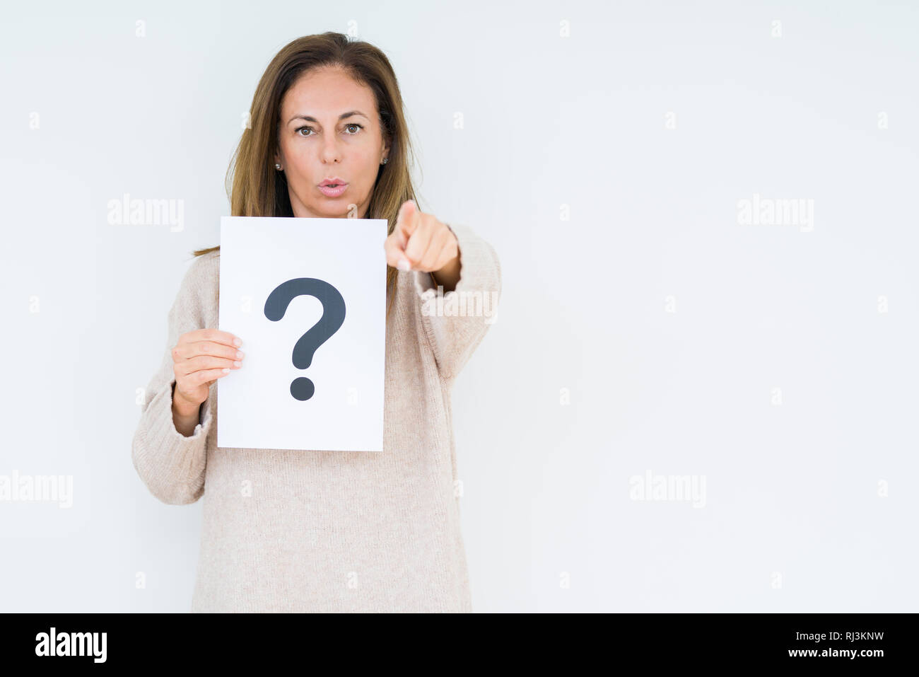 Middle age woman thinking and holding paper with question mark symbol ...