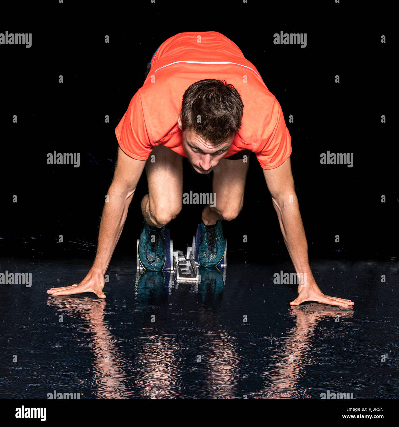 Mann, 20-30 Jahre, Leichtathletik, Sprintstart, Wasserspiegelung Stock Photo