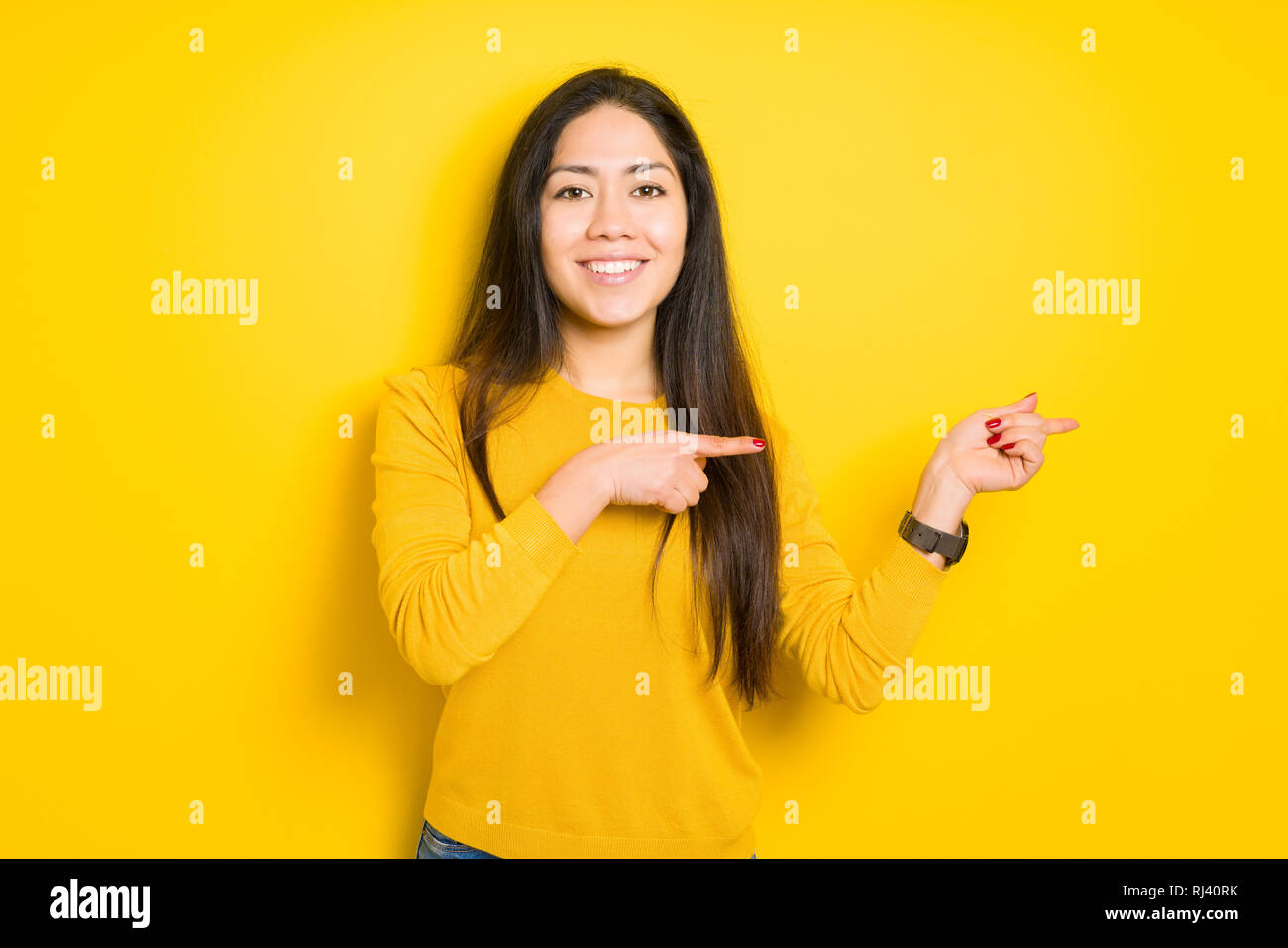 Beautiful brunette woman over yellow isolated background smiling and ...