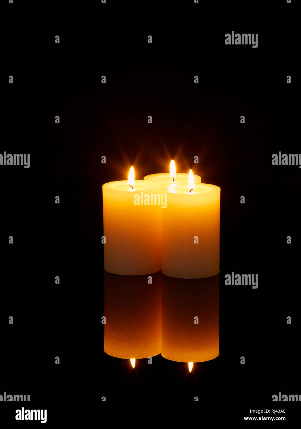 Kerzen mit Spiegelung angez?ndet auf einem Tisch Stock Photo