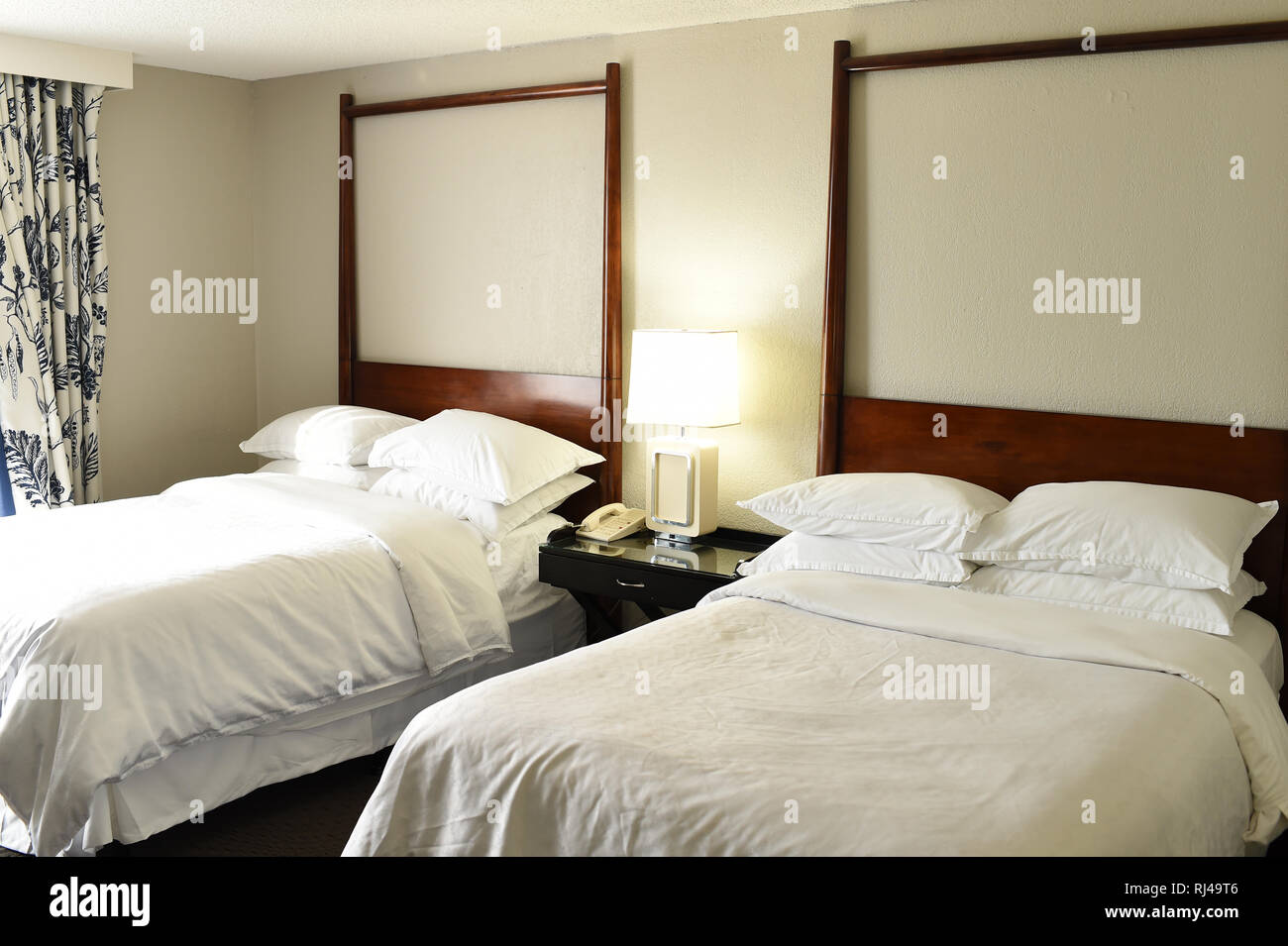 Two Beds With White Linen And Pillows In Hotel Or Motel Room