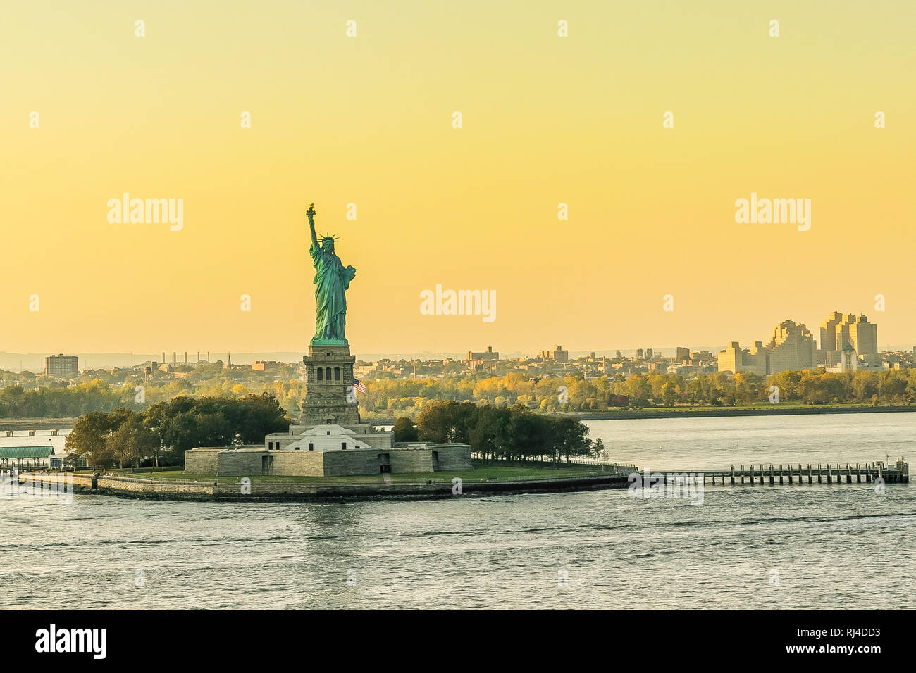 Sunset behind the Statue of Liberty in New York City. Copy Space for text. Stock Photo