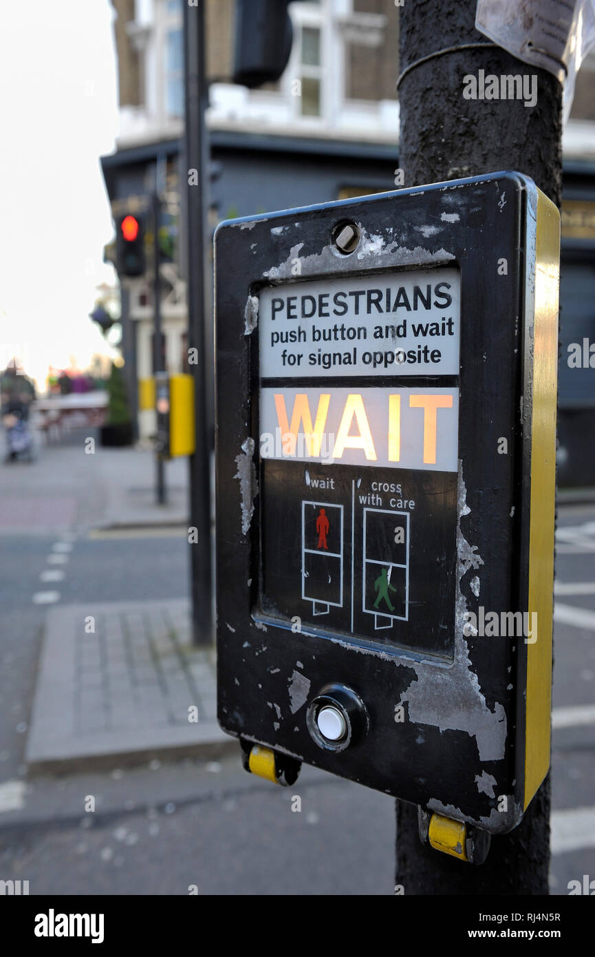 das Wort wait leuchtet auf einer Fußgängerampel in London Stock Photo