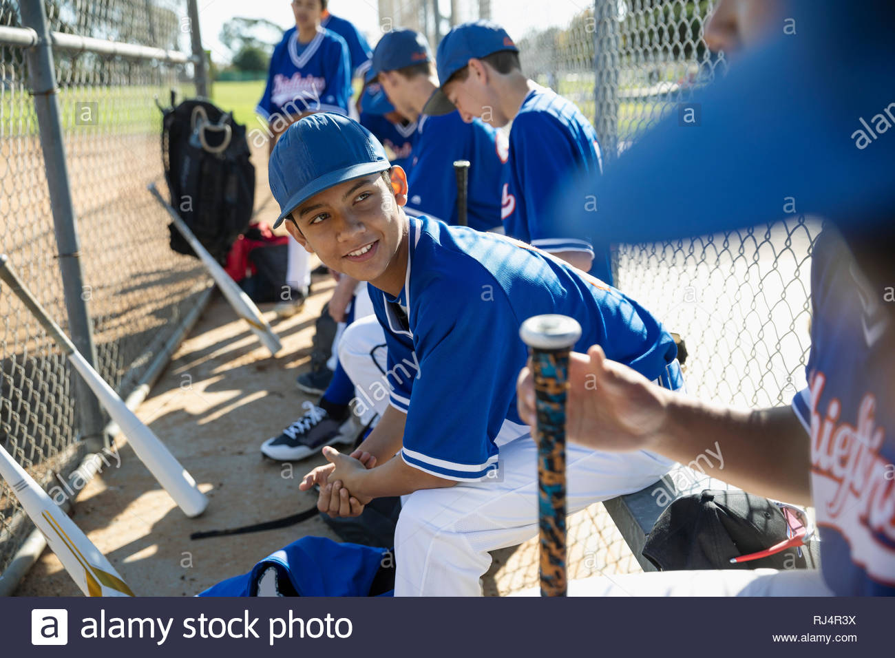 Latinx baseball players talking on bench Stock Photo Alamy