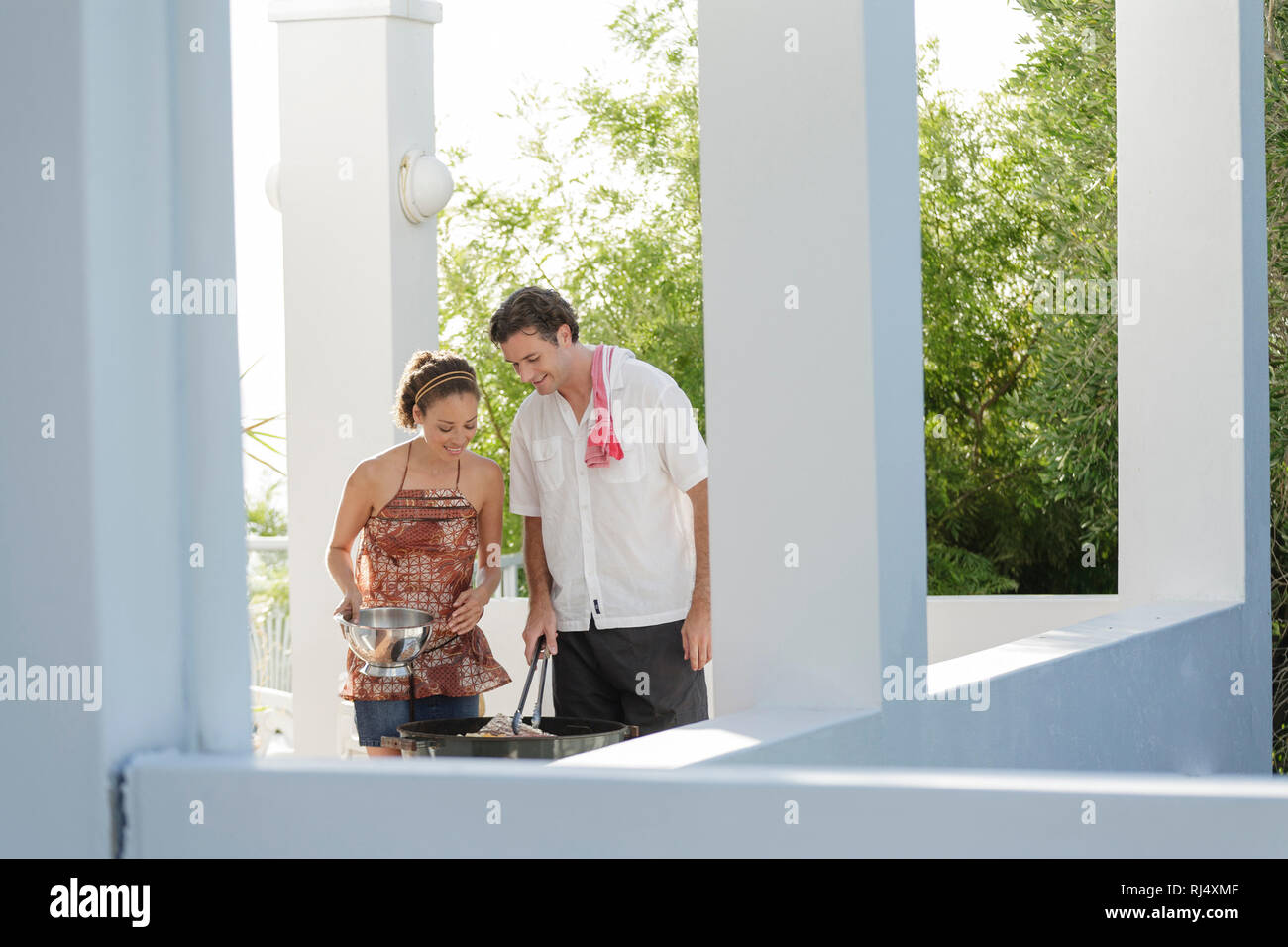 Paar beim Grillen auf Terrasse Stock Photo