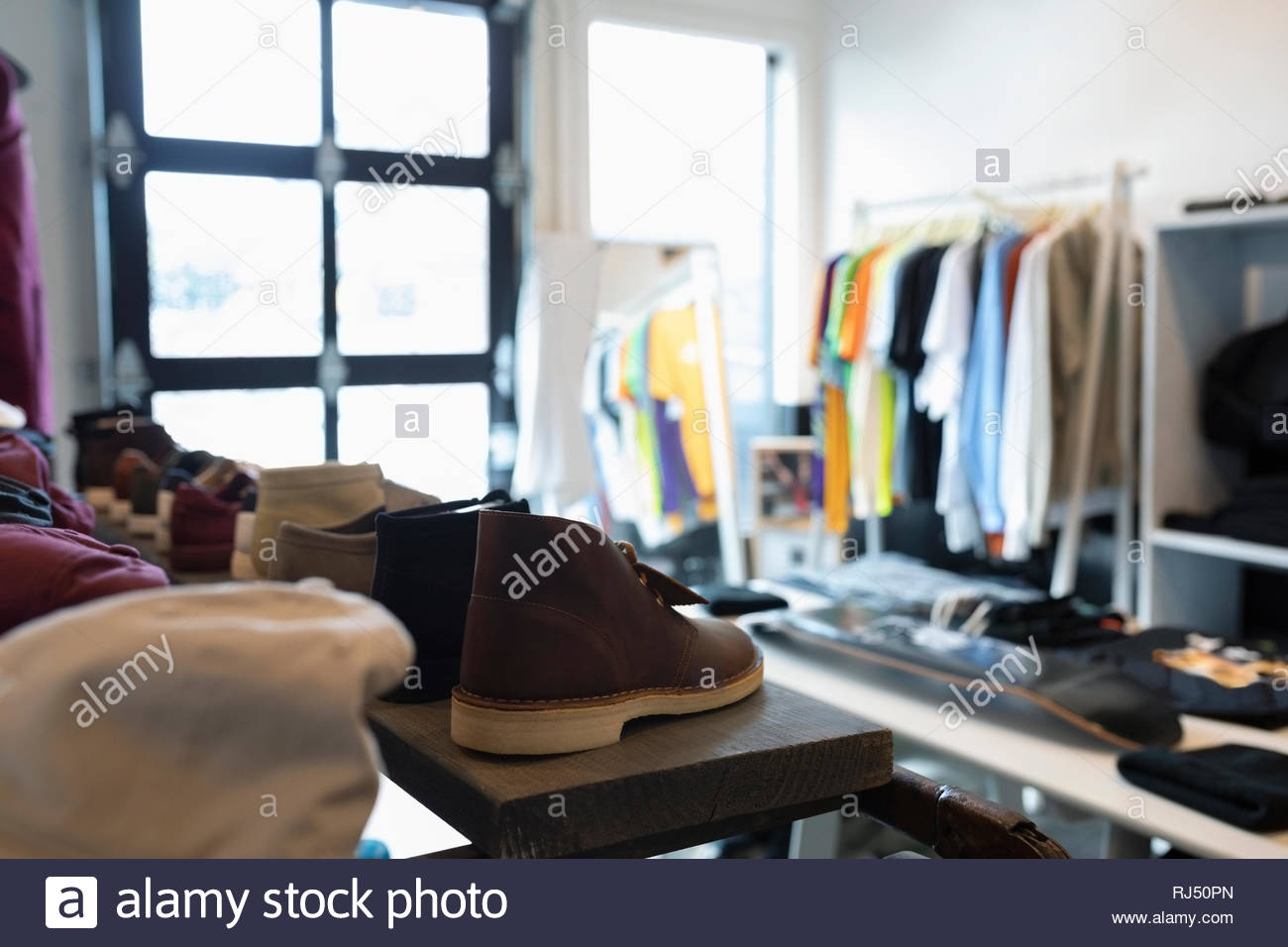 Clothing and shoes in menswear clothing shop Stock Photo