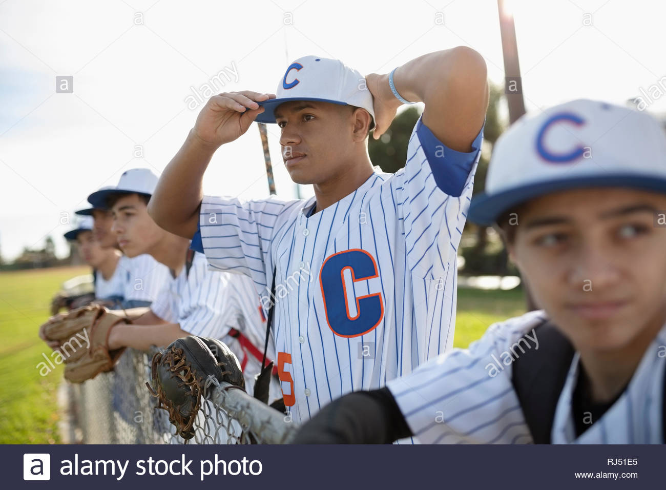Determined baseball player adjusting hat Stock Photo