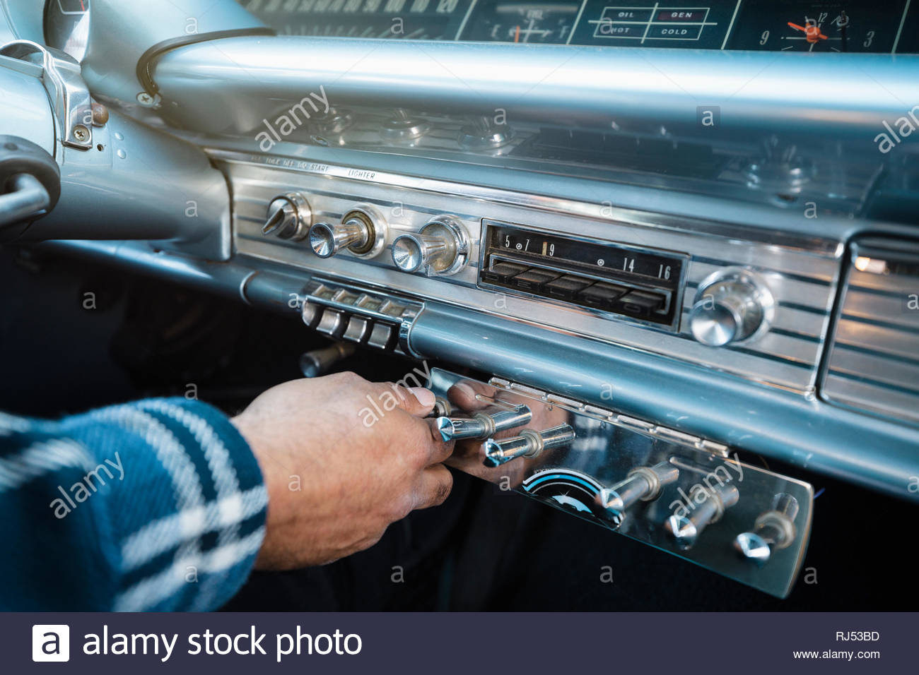 Close up man adjusting dial in low rider vintage car Stock Photo