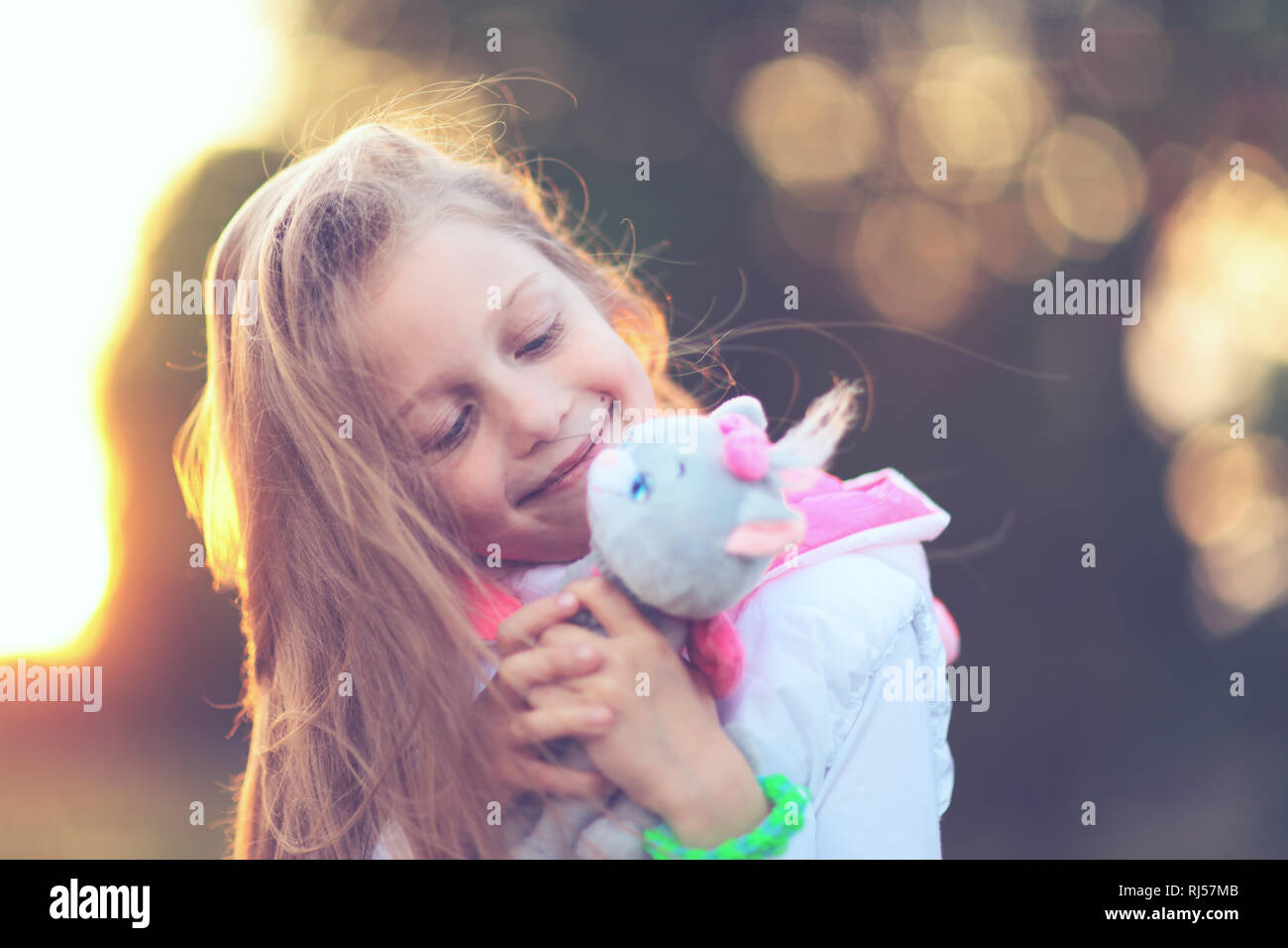 pretty little girl hugging a favorite stuffed animal - a cat for Stock ...