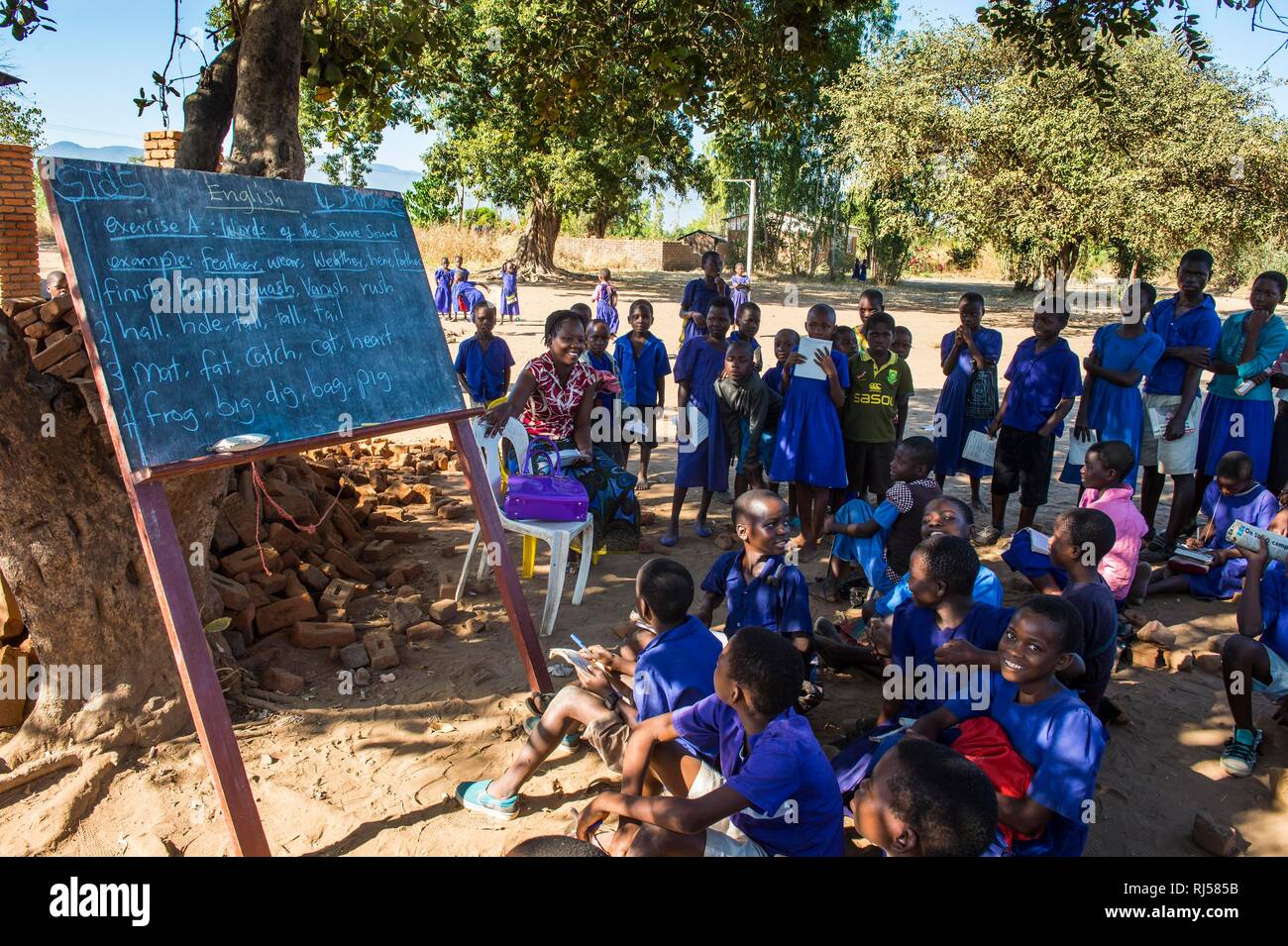 Primary school outside with many children, pupils in class uniform, Liwonde National Park, Malawi Stock Photo
