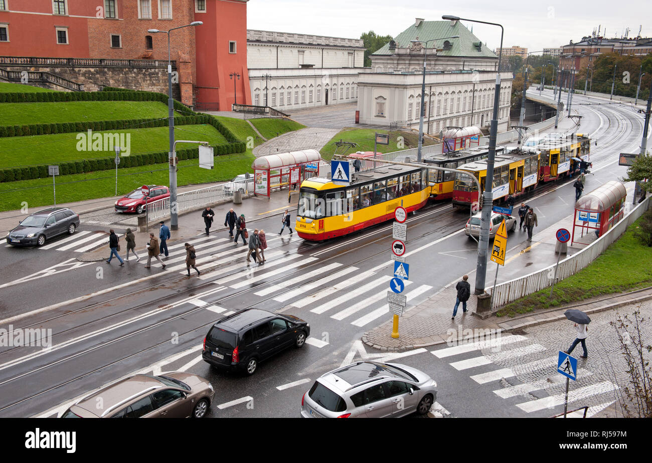Cars and tramcars public transport in Warsaw, view from Old Town, Rainy day, pedestrians walk on zebra crossing, Poland, Europe, Stock Photo