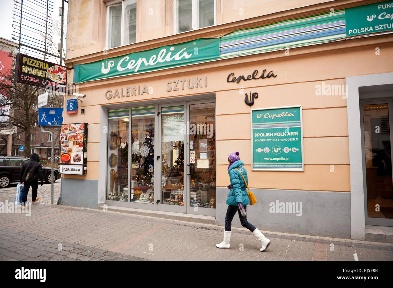 Girl walking in front of Polish Cepelia art gallery shop with handmade craft boutique in Warsaw, Poland, Chmielna St, Stock Photo