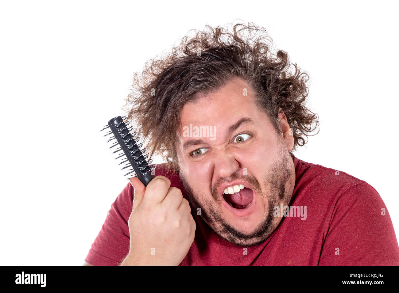 Close up portrait of fat man tries to comb his tangled and naughty hair ...