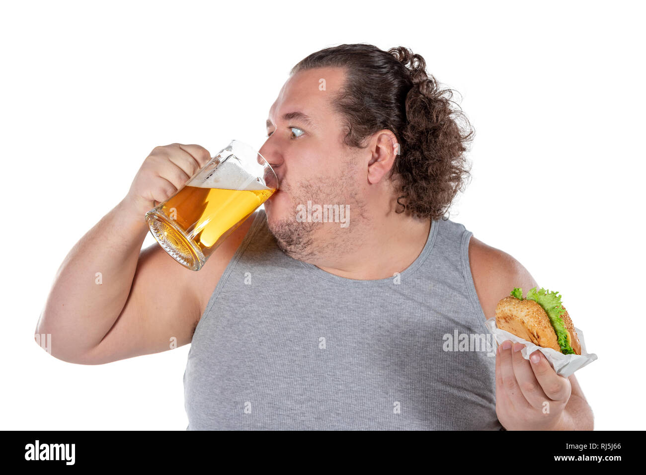 Funny fat man eating burger and drinking alcohol beverage Stock Photo