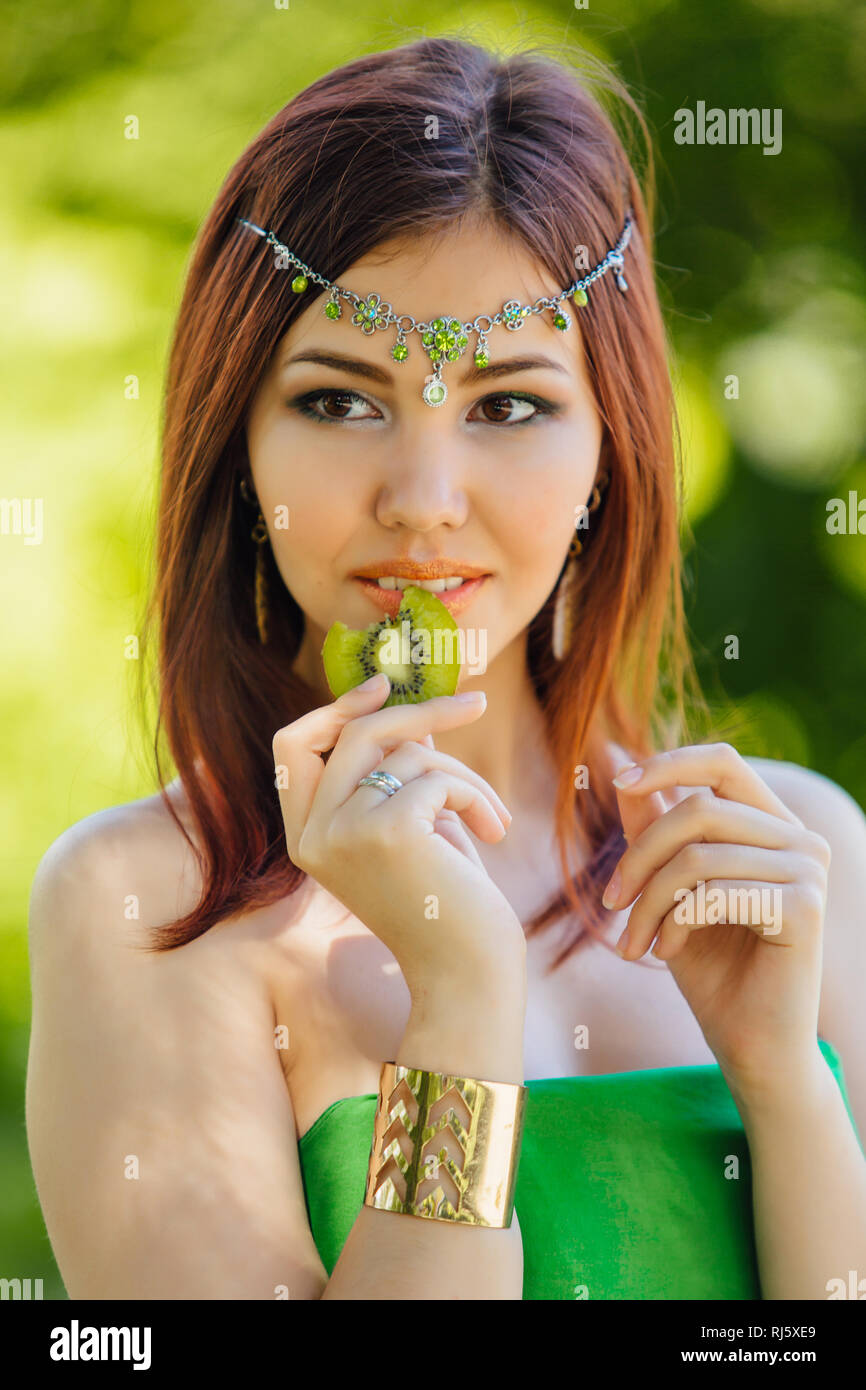 Portrait of a beautiful young asian woman in green dress and diadema on ...