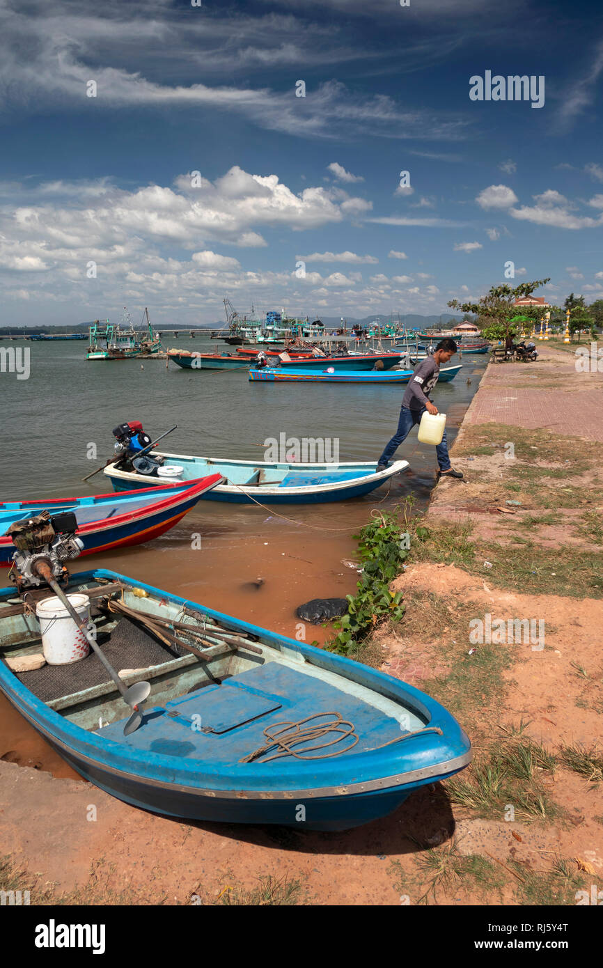 Cambodia, Preah Koh Kong, man stepping off colourful fishing boat tender moored on Prek Kaoh Pao river Stock Photo