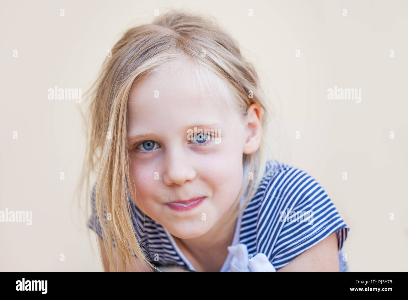 Cute little girl in blue dress drinking milk and smiling outdoors Stock ...