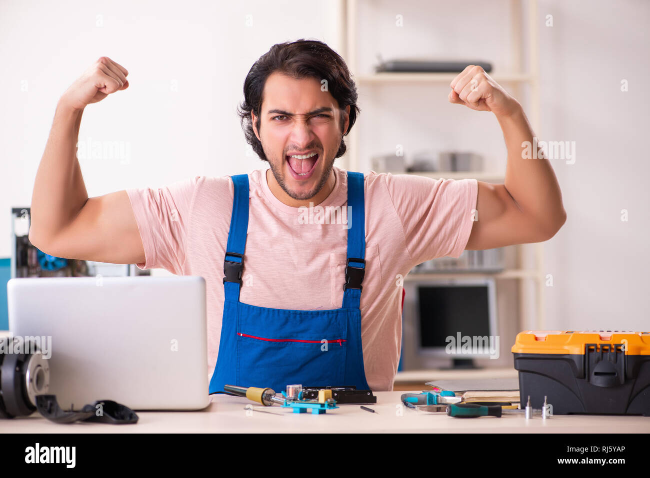 Young male contractor repairing computer Stock Photo