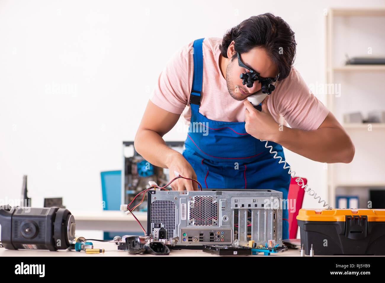 Young male contractor repairing computer Stock Photo