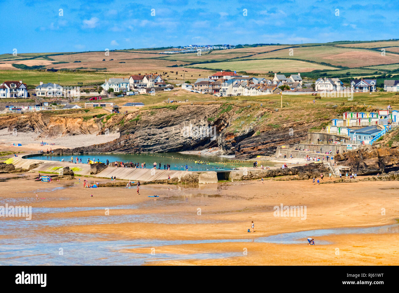6 July 2018: Bude, Cornwall, UK - The beach and tidal swimming pool, with the town and hills beyond, during the summer heatwave. The hills are showing Stock Photo