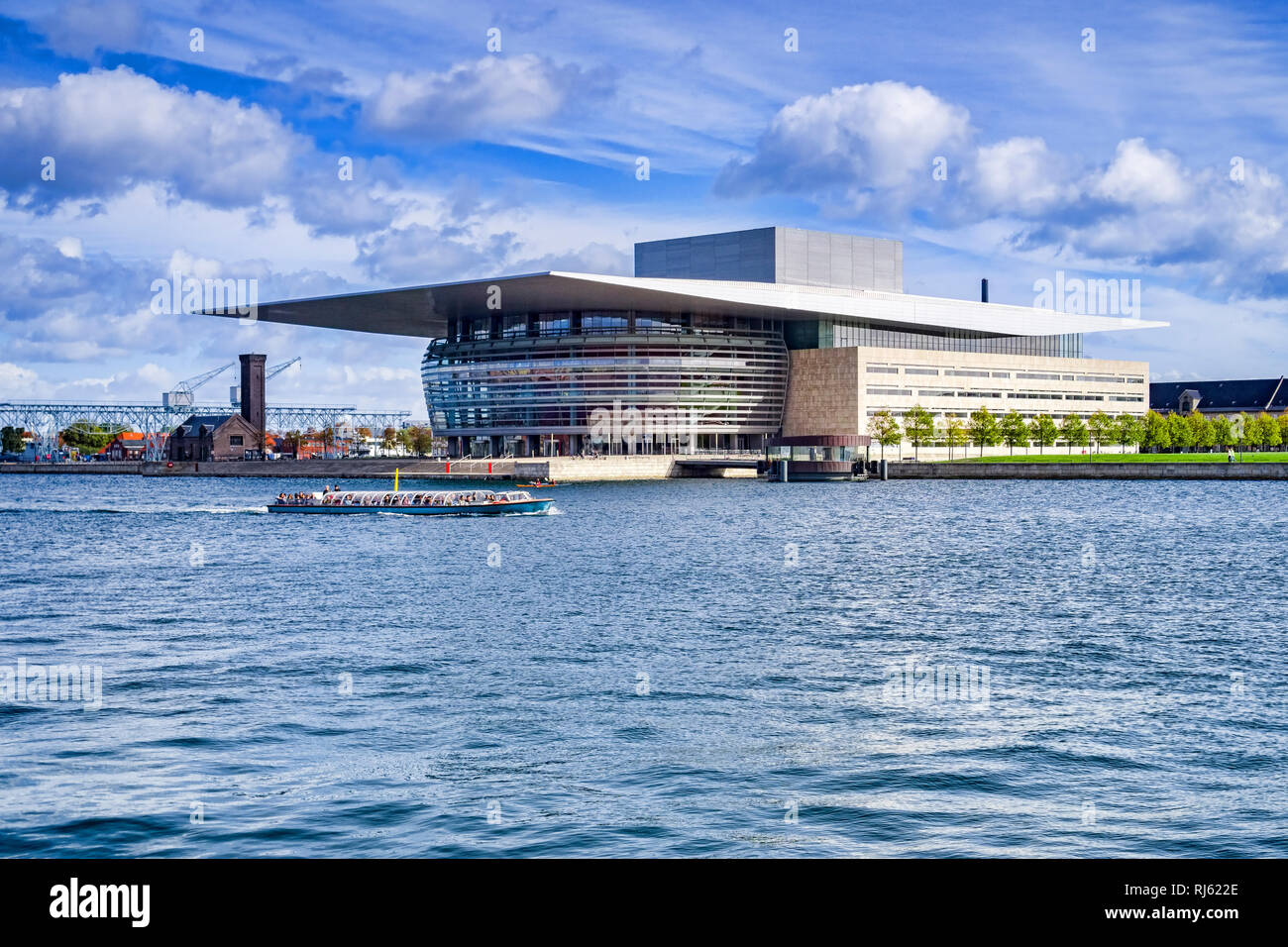 23 September 2018: Copenhagen, Denmark - The Copenhagen Opera House, or Operaen, on Holmen Island, with a tourist boat passing on the harbour. Stock Photo