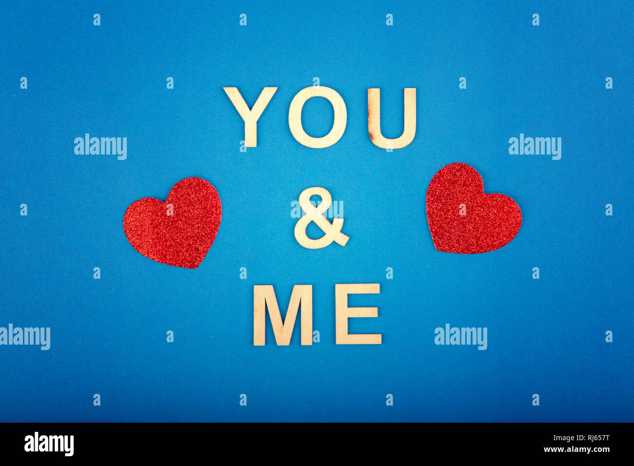 Happy Valentine Day. Beautiful card wallpaper with two red hearts on blue  background. Concept of love February holiday. Wooden words letters saying y  Stock Photo - Alamy