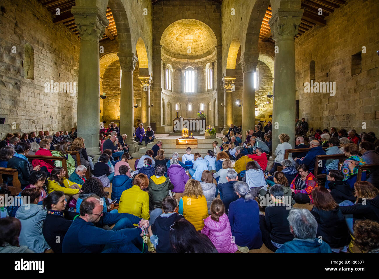 People are gathering and praying inside the church Pieve di San Pietro a Romena Stock Photo