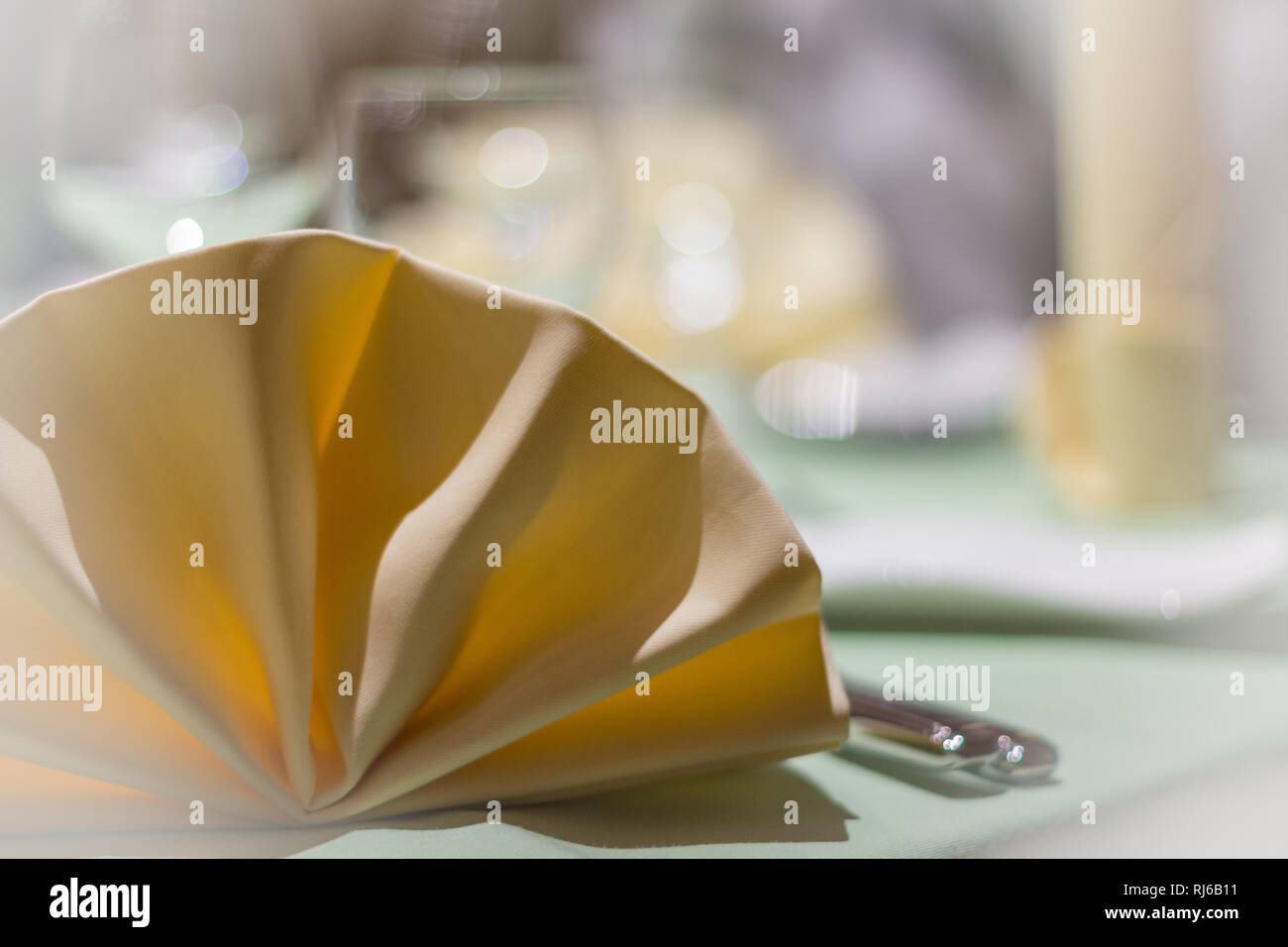 Eine gefaltete Stoffserviette auf einem gedeckten Tisch, Detailaufnahme Stock Photo