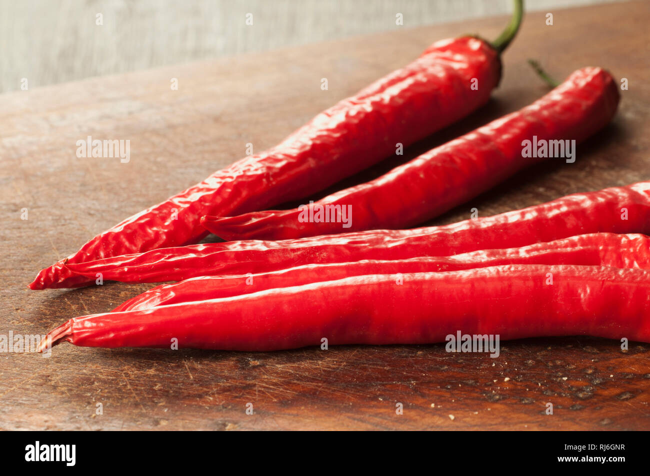 Red chilly peppers on a timber board Stock Photo - Alamy