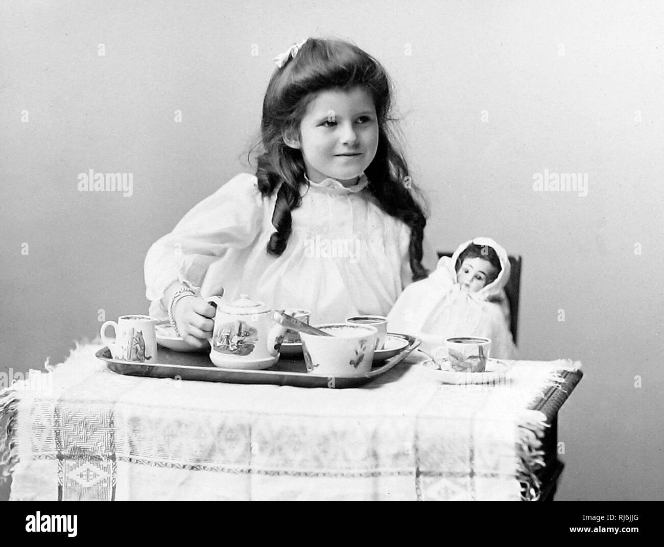 Girl and doll tea party Stock Photo